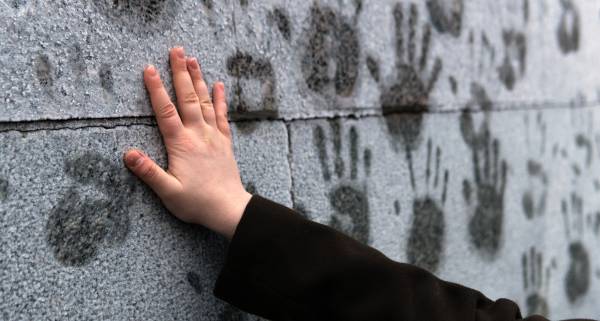 Young girl puts her hand on a frosted wall to leave a print in support of Alexei Navalny during a rally against his arrest in Moscow on January 23, 2021.